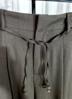 Détail de la ceinture d’un pantalon chocolat avec cordon décoratif