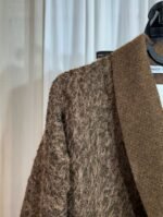 Détail de l’épaule et du col d’un manteau marron texturé — Mesdames Akbelles