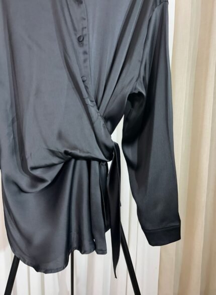 Détail de la chemise noire satinée avec nouage latéral