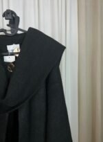 Cape noire avec col large et boutons dorés décoratifs
