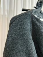 Détail de l’épaule et du tissu d’une cape pull gris foncé — Mesdames Akbelles