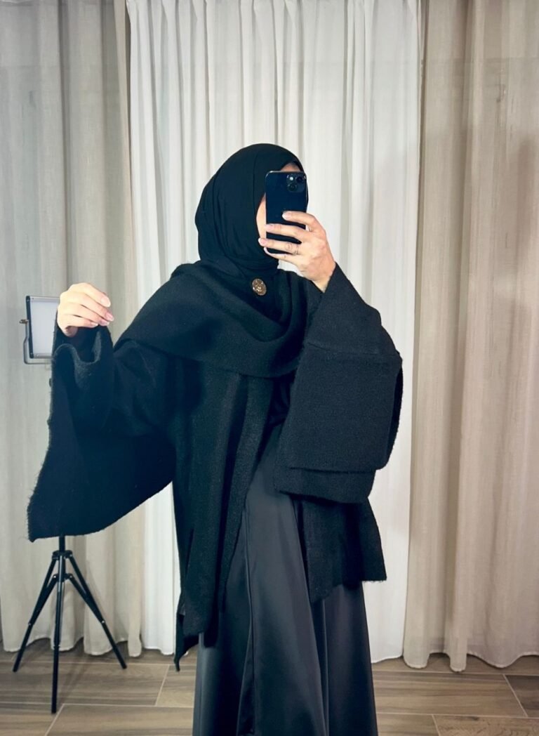 Cape noire élégante avec bouton doré portée avec hijab noir