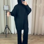 Femme portant un ensemble noir avec tunique oversize et pantalon droit