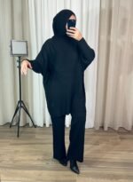 Femme portant un ensemble noir avec tunique oversize et pantalon droit