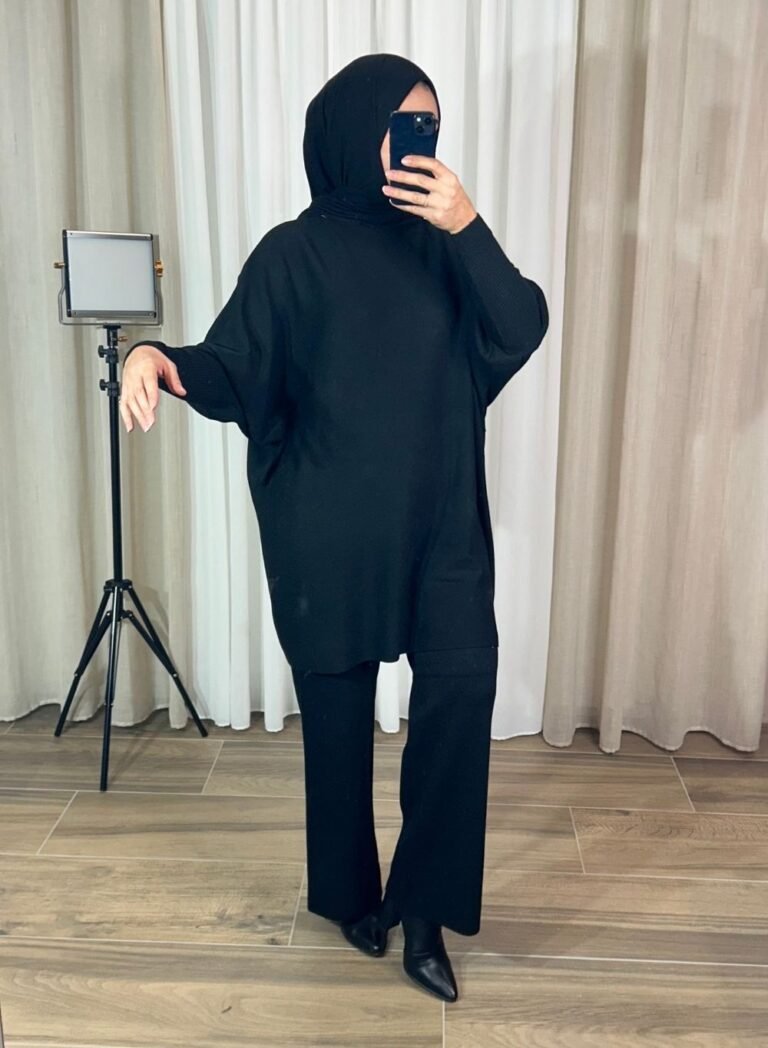 Femme portant un ensemble noir avec tunique oversize et pantalon droit