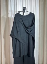 Pull tunique oversize noir suspendu sur cintre avec manches chauve-souris