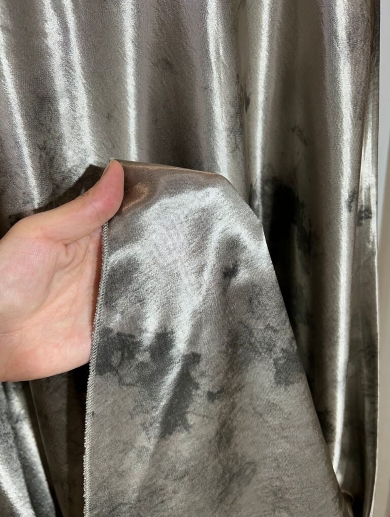 Détail du tissu satiné argenté effet marbré d’une jupe longue — Mesdames Akbelles