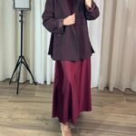 Jupe longue satinée bordeaux portée avec blazer marron et hijab assorti