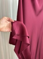 Détail du tissu satiné bordeaux de la jupe longue fluide