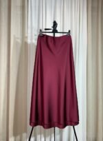 Jupe longue en satin bordeaux fluide et évasée sur cintre