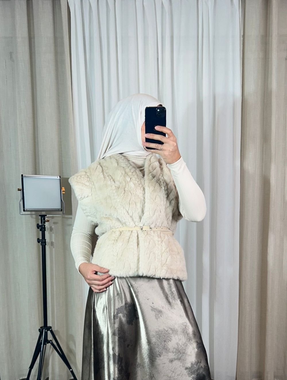 gilet-fourrure-sans-manches-blanc-elegant-mesdames-akbelles Gilet sans manches en fausse fourrure blanche porté avec jupe satinée.