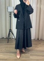 Veste noire croisée avec boutons bijoux portée par un mannequin