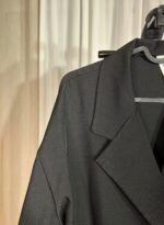 Détail du col tailleur d’une veste noire élégante