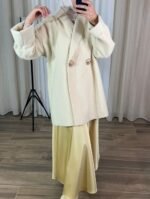 Jupe satinée longue jaune pastel portée avec un manteau clair — Mesdames Akbelles