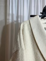 Gros plan sur le tissu texturé d’un manteau oversize crème — Mesdames Akbelles