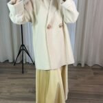 Manteau oversize crème porté, avec boutons dorés — Mesdames Akbelles