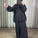 Ensemble fluide 2 pièces marron pour femme composé d'une chemise ample à manches bouffantes et d'un pantalon large, porté avec un hijab assorti.
