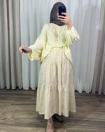 Jupe longue bohème à étages avec motif petites fleurs jaunes, portée avec une blouse fluide jaune clair et un hijab marron.