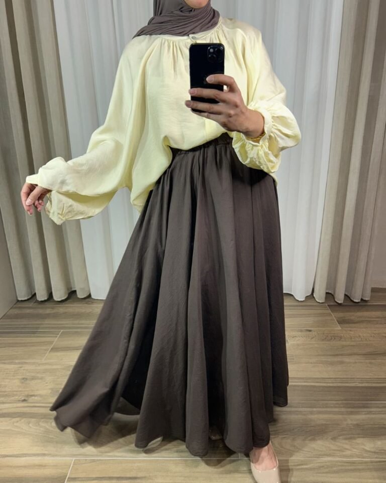 Jupe longue évasée marron chocolat à taille élastique, portée avec une chemise fluide jaune clair et un hijab marron.
