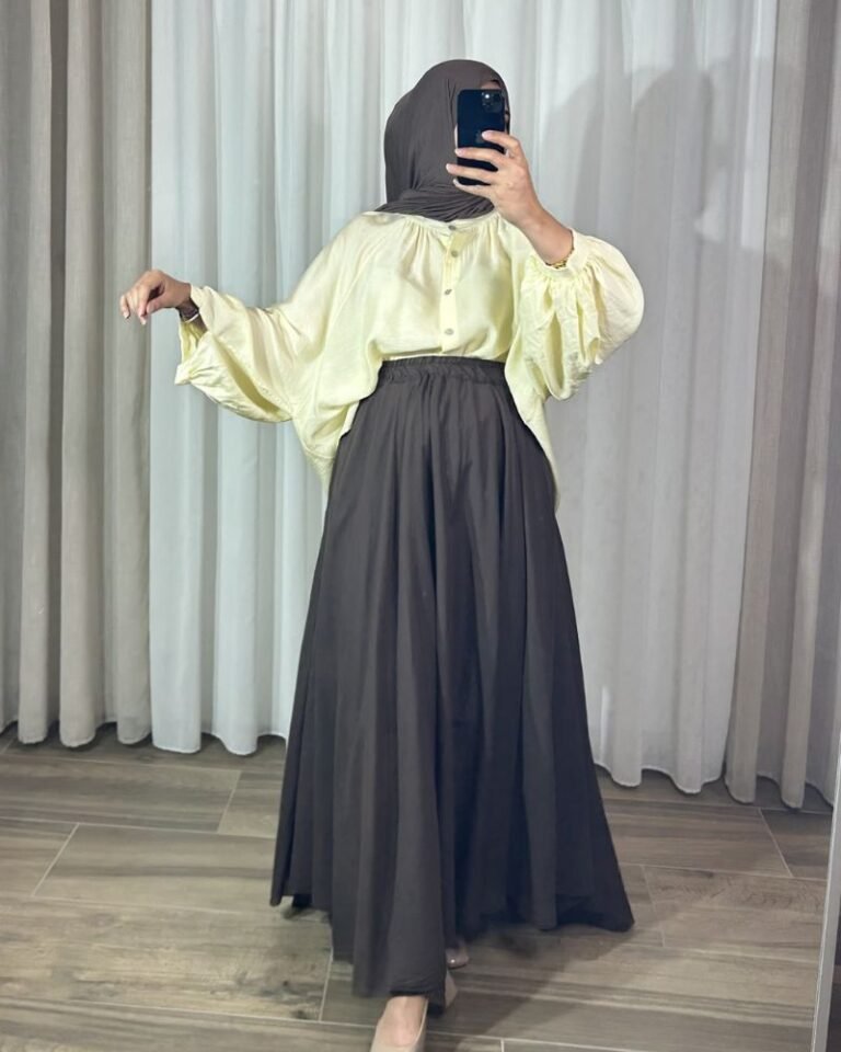Jupe longue évasée marron chocolat à taille élastique, portée avec une chemise fluide jaune clair et un hijab marron.