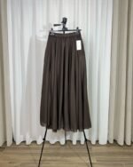 Jupe longue fluide couleur marron chocolat sur cintre, mettant en valeur sa coupe évasée et sa ceinture extensible.