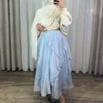 Jupe longue plissée fluide de couleur bleue avec motifs fleurs jaunes, coupe évasée élégante.