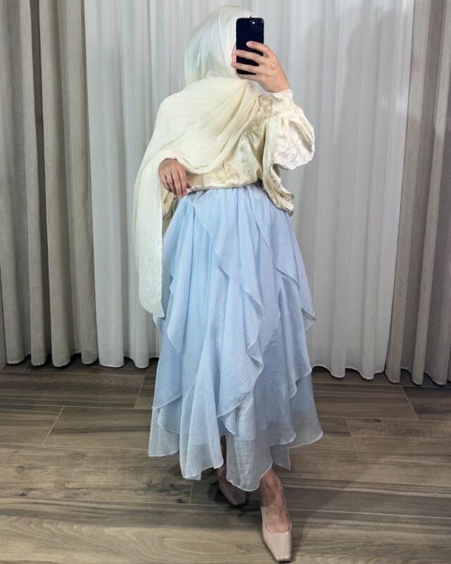 Jupe longue plissée fluide de couleur bleue avec motifs fleurs jaunes, coupe évasée élégante.