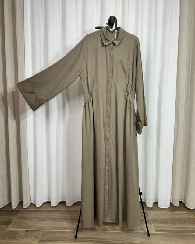 Robe longue fluide couleur taupe sur cintre avec col chemise et poche poitrine.